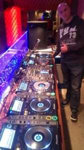 tomislav 1 DJ Tomislav (Tom Black) stoji ispred DJ opreme s pet playera, spreman za nastup na vjenčanju.