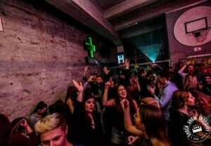 tomislav 11 DJ Tomislav (Tom Black) nasmijan za DJ pultom, okružen rasplesanom publikom na vjenčanju.